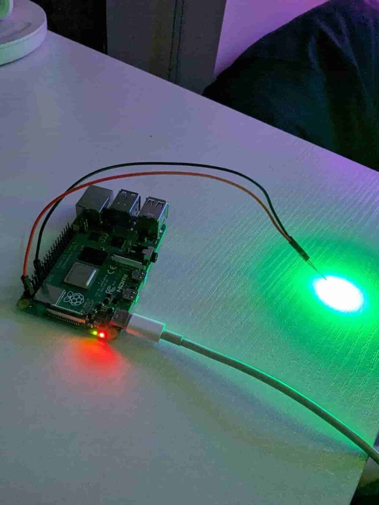a raspberry pi with a bulb connected that is currently glowing